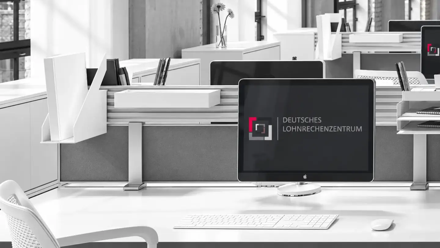 Moderner Büroarbeitsplatz mit Monitor des Deutschen Lohnrechenzentrums zum Honorarmodell der Lohnabrechnung.
